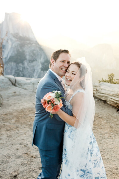 A bride and groom laugh while at Glacier Point in Yosemite National Park. 