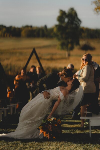 Wedding Couple Dipping and Kissing in the aisle after their ceremony at Diamond in the Rough Wedding Venue