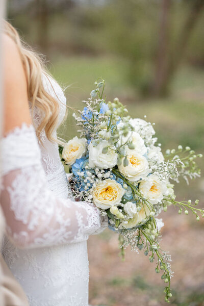 Bride holding blue and yellow floral arrangement — Madison Abernathy Photo