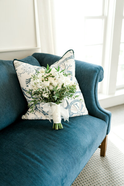 white floral bouquet sitting on blue couch