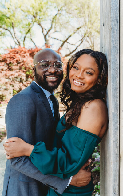 black couple engagement photoshoot at Dallas arboretum botanical garden wearing green dress and navy blue suit portrait photo taken by blessing daniel photography