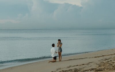man proposes to his girlfriend on the beach
