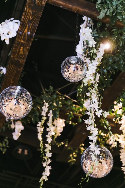 A wedding reception adorned with hanging glass balls and flowers, creating a whimsical and romantic atmosphere.