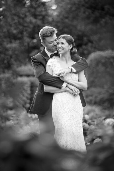 Close up photograph of bride and groom smiling just before they kiss with the golf course of Pine Island Country Club in the background by Charlotte wedding photographers DeLong Photography