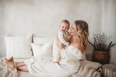 mom sitting on the studio bed holding her baby boy