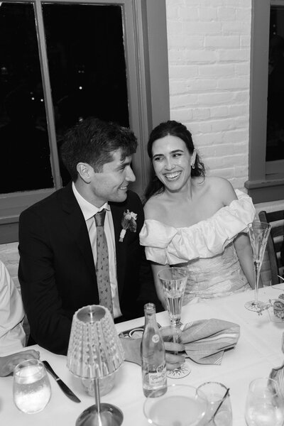 a bride and groom laughing at their wedding reception captured by California documentary wedding photographer.