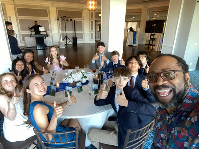 Kids at a table giving thumbs up with DJ Marz