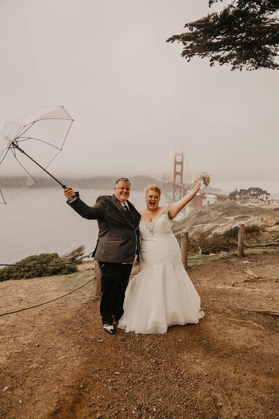 newlyweds in front of bridge