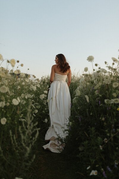 bride in flower field on wedding day in pei