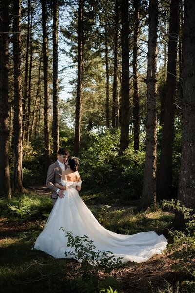 Bruid en bruidegom omhelzen elkaar in het bos, gefotografeerd door Julia de Groot, trouwfotograaf uit Utrecht