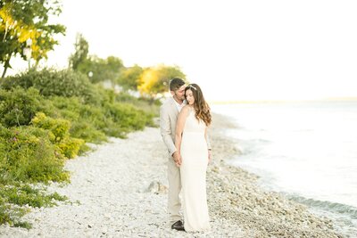 Bride holding a beautiful bouquet of flowers kissing her groom