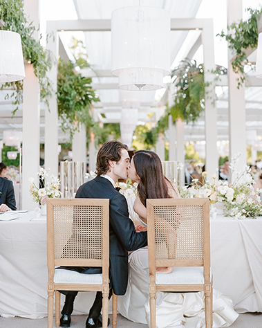 Couple kissing at wedding reception dinner
