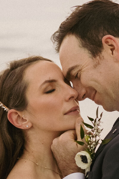 bride smiling while kissing groom