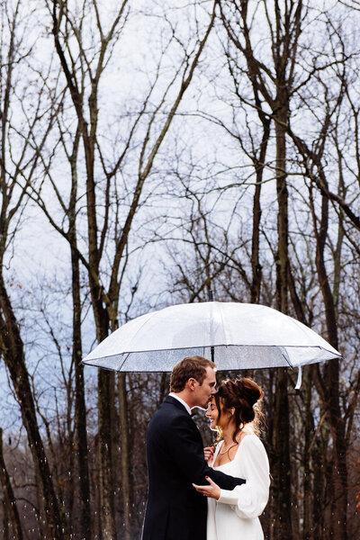 Couple sharing a kiss under an umbrella in the rain