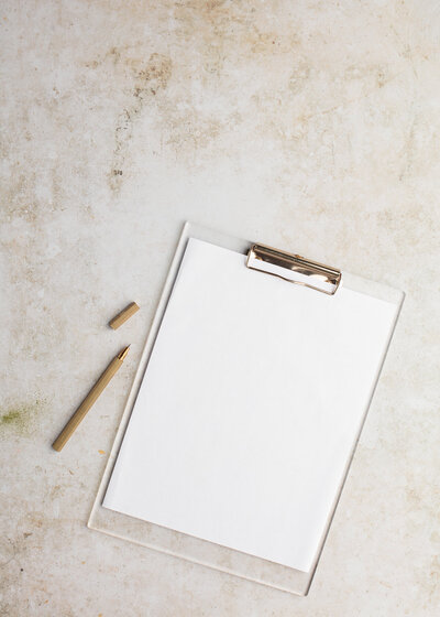 A cream-coloured clipboard with a gold pen