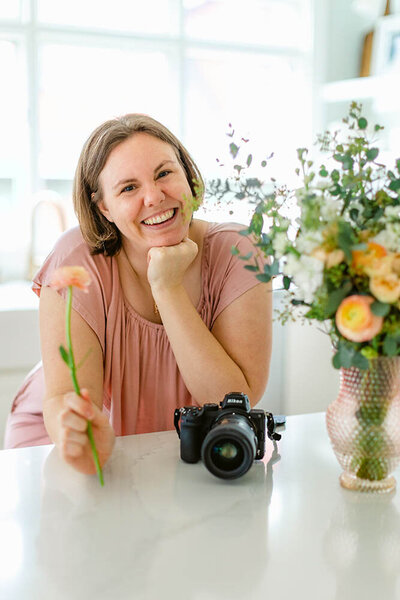 Chicago Portrait Photographer Kristen Hazelton wearing a pink dress and holding a flower