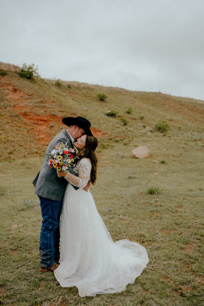 oklahoma wedding photographer documents groom kissing bride on the cheek