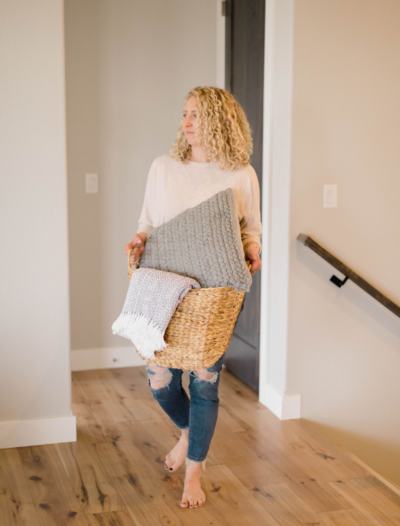 Lauren Haug, Northern Colorado Real Estate  Agent carrying a basket of staging items