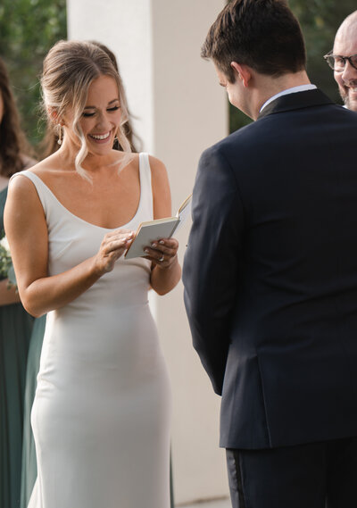 bride gets emotional with husband while reading her wedding vows