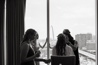candid wedding photo of bridesmaids getting ready in a hotel room