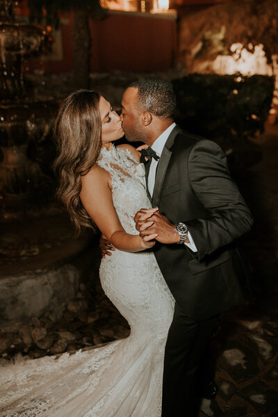 bride and groom dancing while kissing