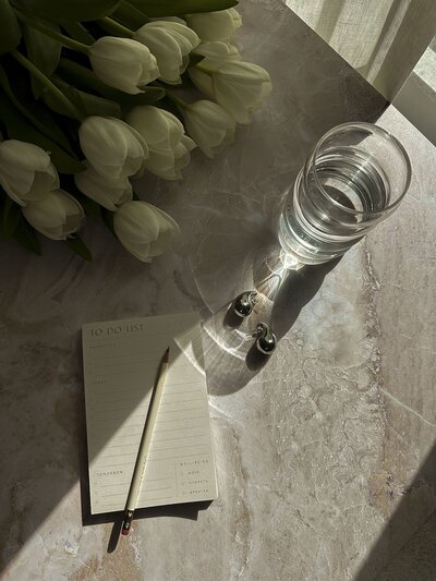 Bouquet of white flowers sitting next to a blank note pad