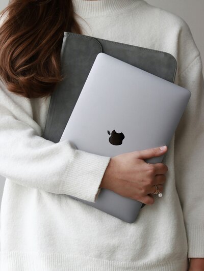social media engagement expertise with our professional adorned in an elegant white outfit, confidently holding a grey laptop in hands
