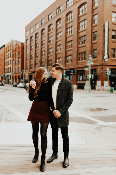 Engagement photo in the city around brick buildings