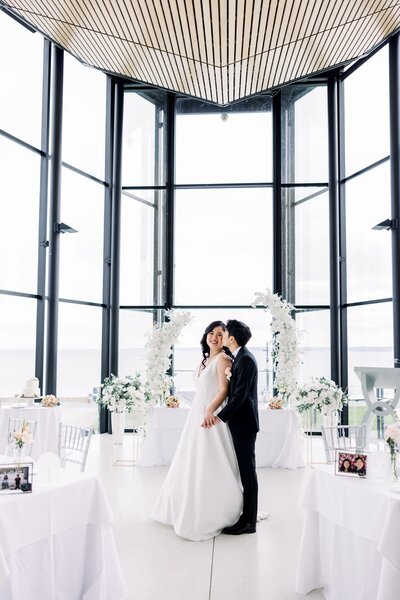 Bride and groom kissing in reception space