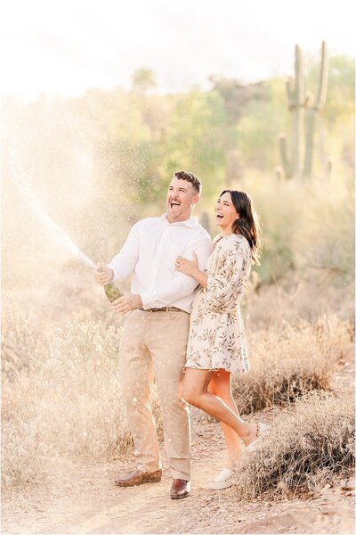 An engagement photo of a couple popping champagne by Joni Loraine Photography, a Portland Oregon wedding photographer