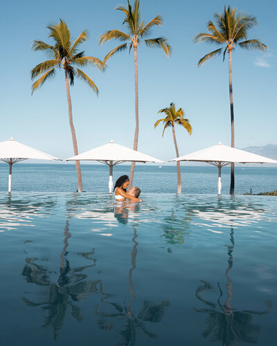 Beautiful couple embrace at the edge of an infinity pool at the Wailea hotel