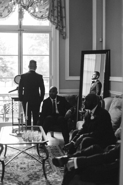 B/W picture of a groom and groomsmen hanging out in a space. 