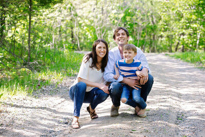 Small family of four sitting on the ground outdoors at their lake property on Ten Mile Lake in Hackensack Minnesota