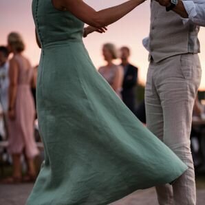 Woman in a flowing green dress dancing at sunset, representing joy, freedom, and renewed connection after completing couples therapy or infidelity recovery with Relationship Experts.
