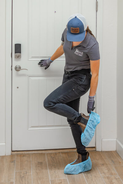 Dove Electric electrician in Albuquerque putting on shoe covers in home