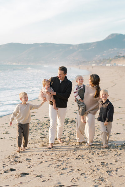 Family of six walks along Westward beach at sunset captured by Malibu photographer.