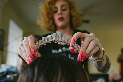 Hair stylist placing crystal crown on Bride's head on her Wedding Day