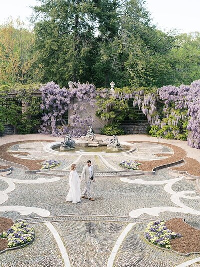 A couple walk across Dumbarton Oaks in Georgetown during their maternity photo session.