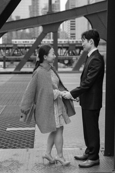 Couple posing for engagement photos outside the Art Institute of Chicago with iconic architecture in the background.