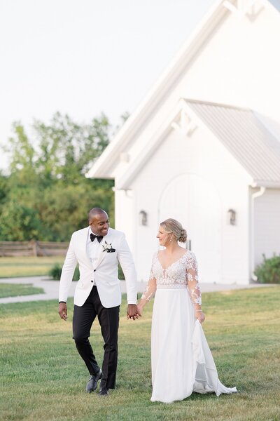 Bride and groom holding hands walking the grounds outside their Ottawa wedding venue