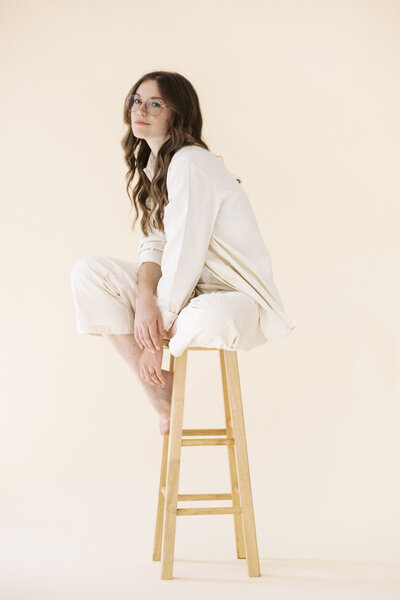 woman sits on stool