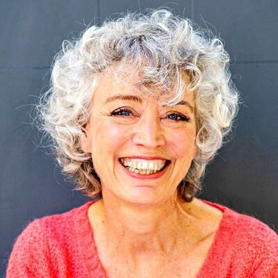 Middle age woman with grey hair enjoying retirement coaching session.
