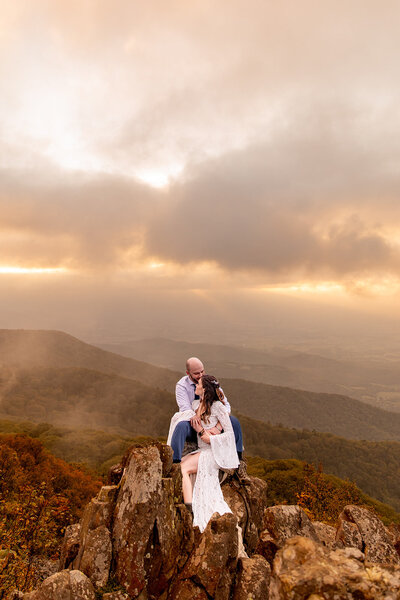 couple sitting together on top of mountain