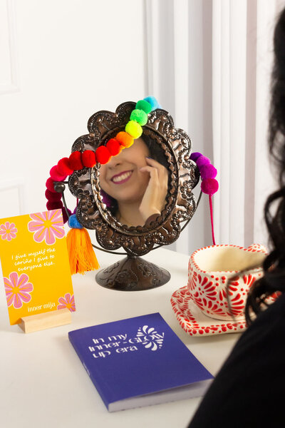 The artful world guided by our founder! Witness her expertise as she holds a branded agenda with the yellow submark logo in both hands. Adorned in a vibrant blue top, a yellow skirt, and showcasing brand-coordinated blue nails.