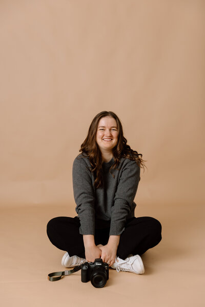 Desiree sitting with her camera in front of her.