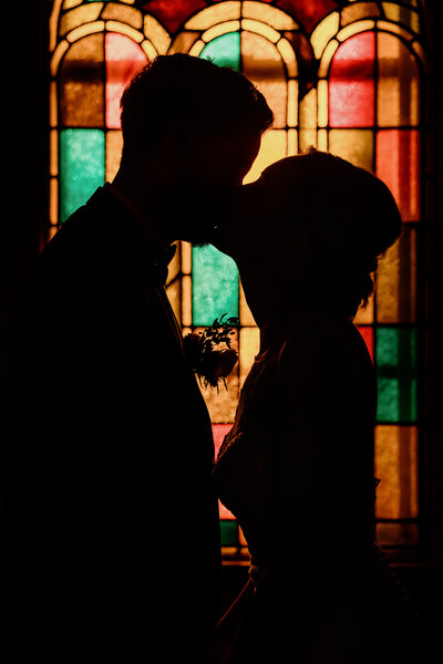 wedding couple in front of horse carriage with red flowers