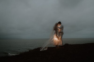 Yeppoon Elopement On a cliff over looking the ocean. In blue hour the couple hold lanterns