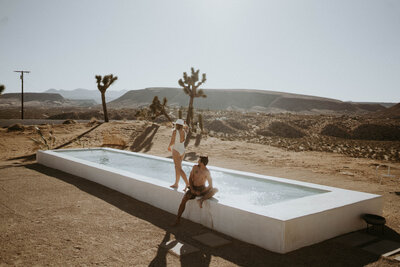 couples session in joshua tree california near a pool in bathing suits