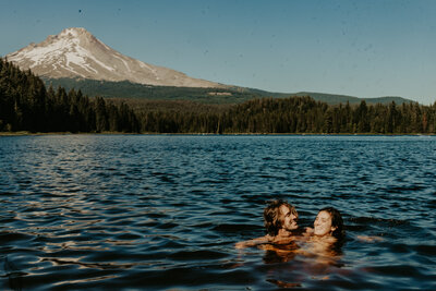 Couple kissing while sitting down on their picnic cloth