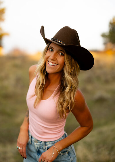 Montana photographer posing with her camera in hand and smiling.